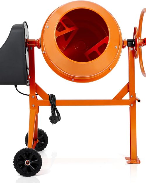 Construction worker in PPE using a large orange electric cement mixer with handwheel on a sandy jobsite