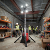 Milwaukee MX FUEL LED lighting tower illuminating an indoor construction site with workers and materials